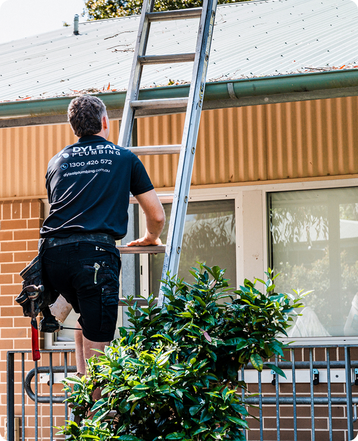 DYLSAL plumber inspecting a residential roof for accurate leak diagnosis